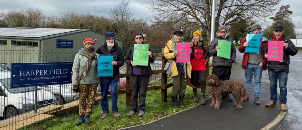 another photo of 8 people with placards protesting the sale of Nazi memorabilia, at Harper Field